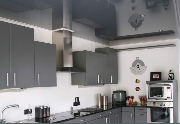 Modern renovierte graue Küche mit grauer Glanzspanndecke für eine elegante und einheitliche Deckengestaltung.